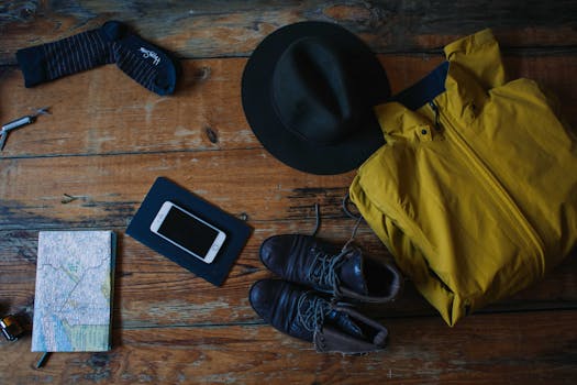 A flatlay of travel essentials on a rustic wooden table, ideal for adventurers.